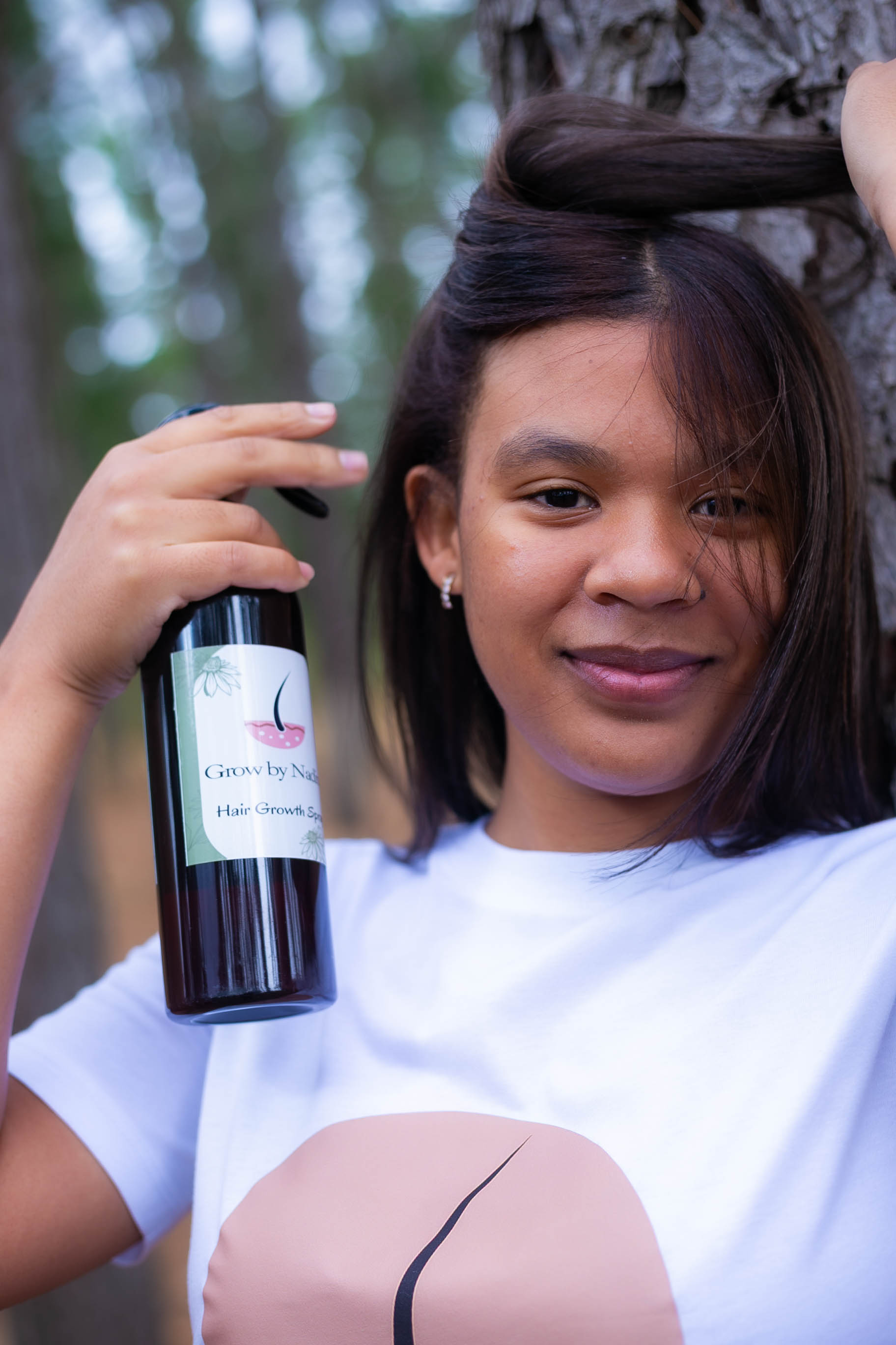 Applying Grow by Nadine Hair Growth Spray to the scalp